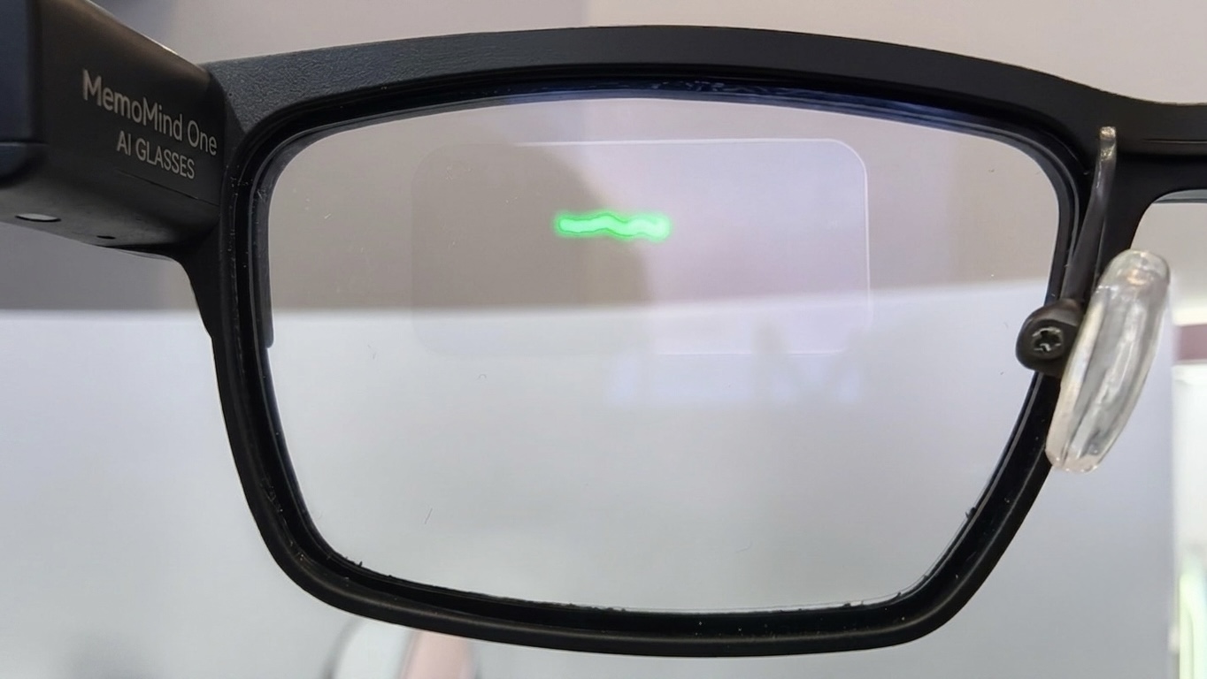 Close-up of the MemoMind One lens showing a green waveform icon projected onto the transparent display